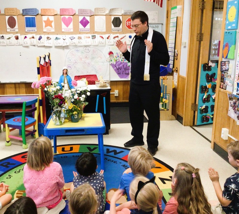 Father John blesses children